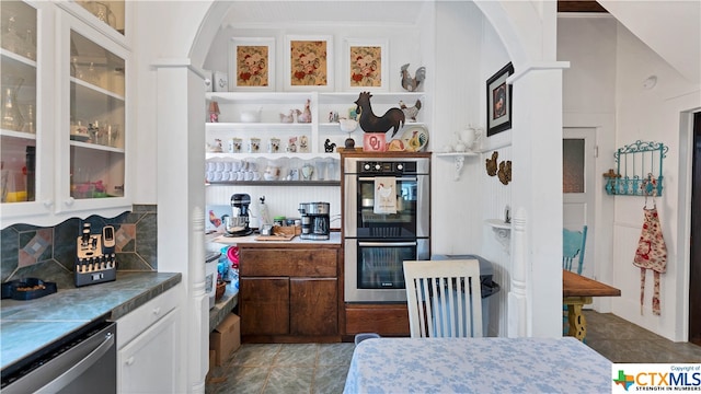 interior space featuring white cabinetry, appliances with stainless steel finishes, light tile patterned floors, and tasteful backsplash