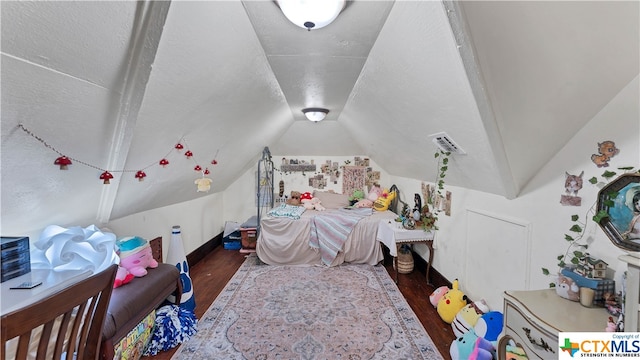 bedroom featuring dark wood-type flooring and vaulted ceiling