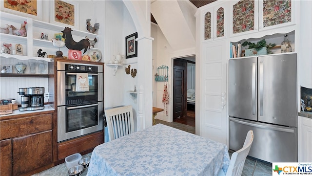 kitchen with white cabinets, appliances with stainless steel finishes, and dark tile patterned flooring