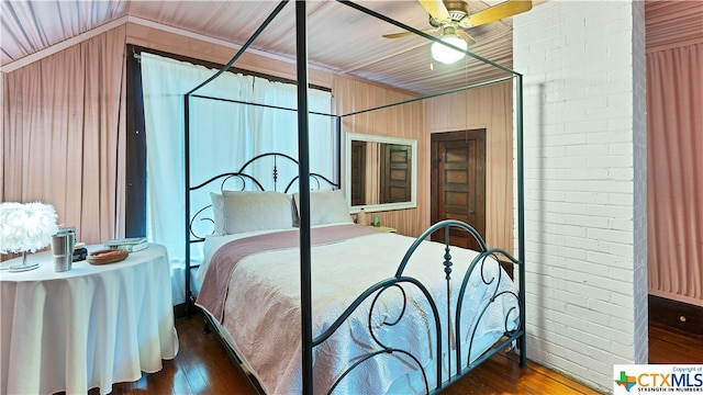 bedroom featuring dark hardwood / wood-style flooring, brick wall, ceiling fan, and vaulted ceiling