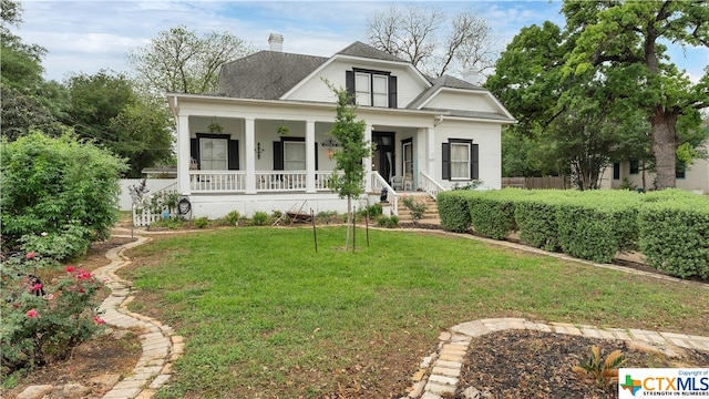 view of front of house featuring a front lawn and covered porch