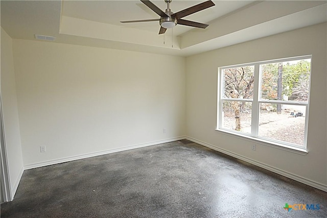 empty room with a tray ceiling and ceiling fan