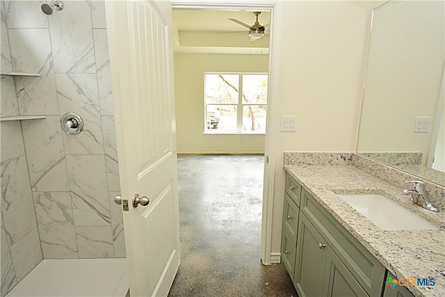 bathroom featuring vanity, a tile shower, and ceiling fan