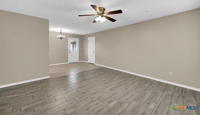 1117 Lindsey Cir, Belton, TX 76513 - unfurnished room featuring baseboards, a textured ceiling, wood finished floors, and ceiling fan with notable chandelier