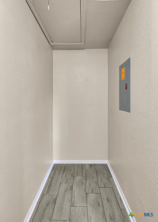 1117 Lindsey Cir, Belton, TX 76513 - spare room featuring electric panel, baseboards, attic access, and wood tiled floor