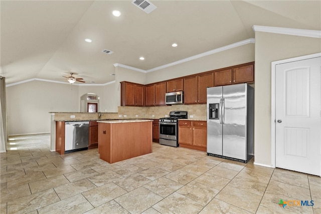 kitchen with crown molding, stainless steel appliances, a kitchen island, decorative backsplash, and ceiling fan