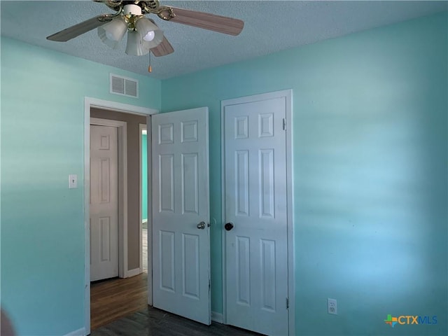 701 S 19th St, Copperas Cove, TX 76522 - unfurnished bedroom featuring dark wood-style flooring, a textured ceiling, and a ceiling fan