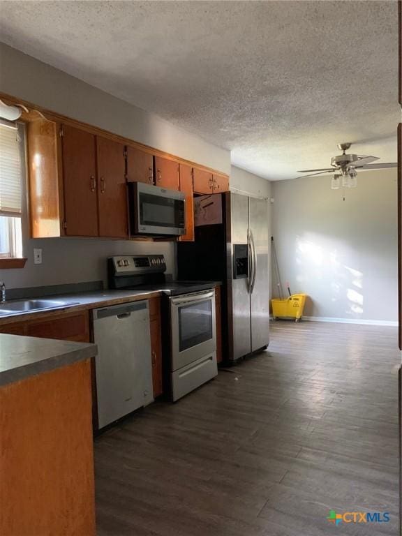 701 S 19th St, Copperas Cove, TX 76522 - kitchen with stainless steel appliances, a textured ceiling, dark wood finished floors, dark countertops, and a ceiling fan
