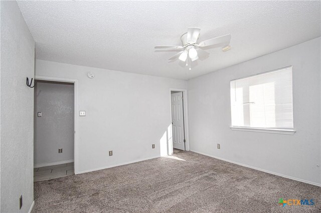 carpeted bedroom featuring a textured ceiling and ceiling fan