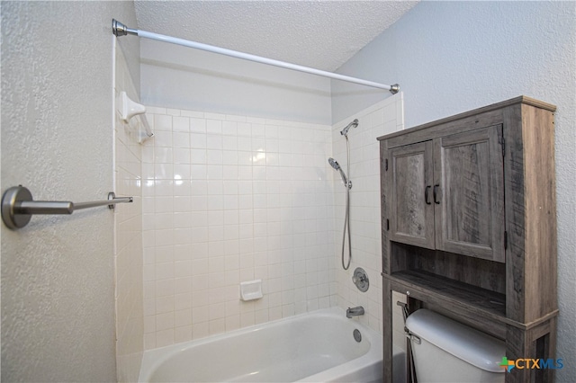 bathroom with a textured ceiling, shower / bathtub combination, and toilet