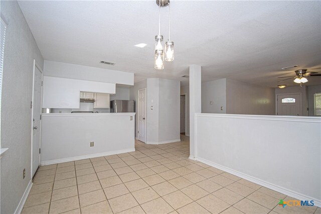 tiled spare room featuring a textured ceiling and ceiling fan