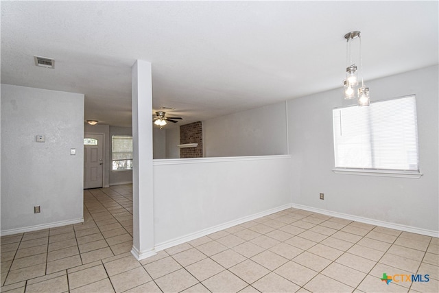 tiled spare room featuring ceiling fan