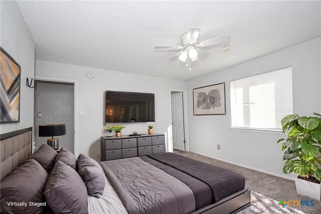 unfurnished bedroom featuring a textured ceiling, ceiling fan, carpet flooring, and multiple closets