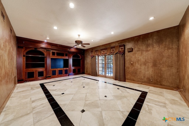 unfurnished living room featuring a textured ceiling, ceiling fan, and french doors