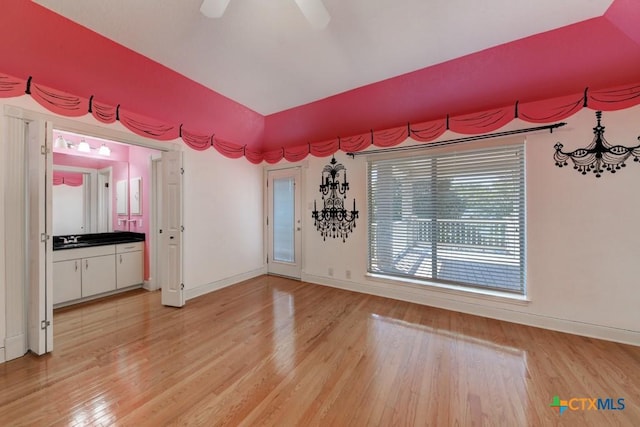 empty room featuring sink, ceiling fan, and light wood-type flooring