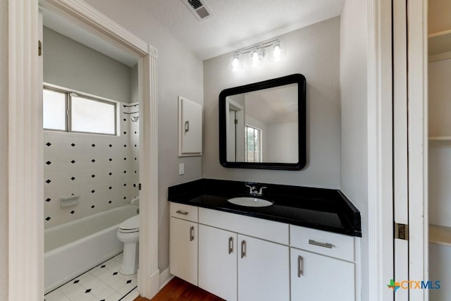 full bathroom featuring vanity, tiled shower / bath, tile patterned floors, and toilet