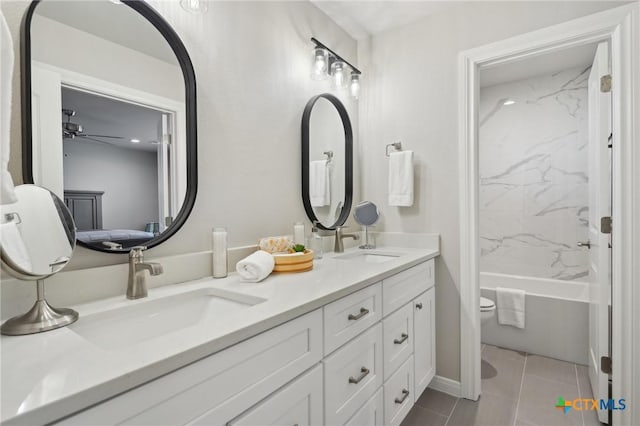 bathroom with tiled shower / bath combo, vanity, and tile patterned flooring