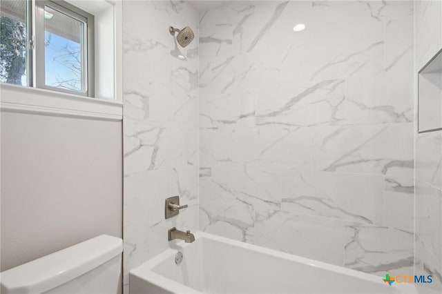 bathroom featuring toilet and tiled shower / bath combo