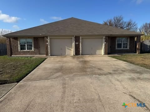 ranch-style house with a front yard and a garage