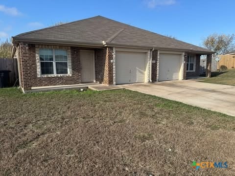 ranch-style house featuring a front lawn and a garage