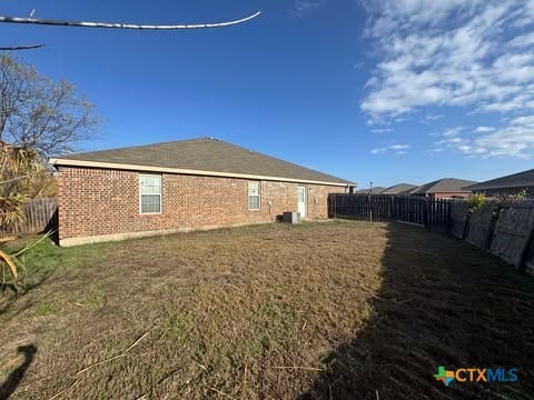 back of property with a yard and cooling unit