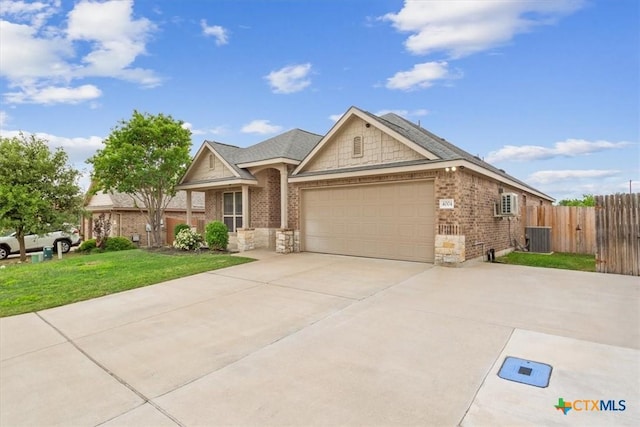 ranch-style home featuring a front lawn, fence, brick siding, concrete driveway, and an attached garage