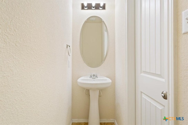 bathroom featuring a textured wall