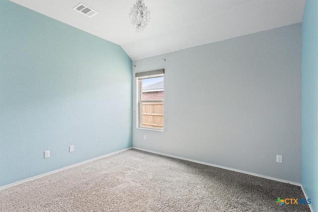 carpeted spare room with visible vents, baseboards, and vaulted ceiling