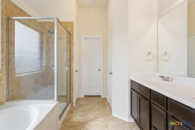 bathroom with vanity, tile patterned floors, baseboards, a shower stall, and a garden tub