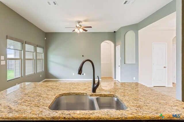 4004 Brookhaven Dr, Temple, TX 76504 - kitchen featuring a sink, arched walkways, and light stone counters