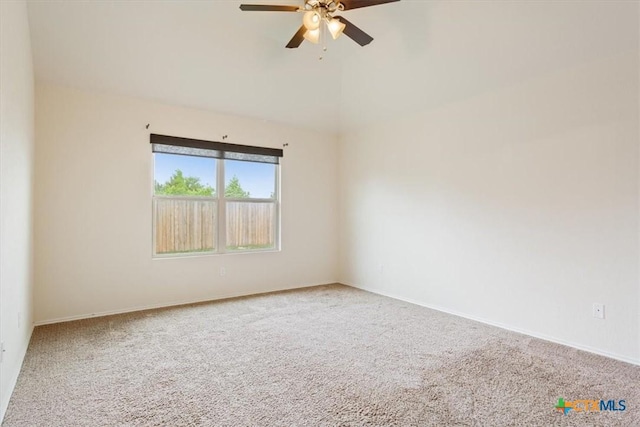 empty room featuring baseboards, carpet, ceiling fan, and lofted ceiling