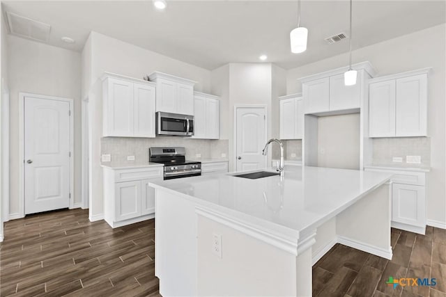 812 Waylon Cir, Killeen, TX 76542 - kitchen with appliances with stainless steel finishes, dark wood-style flooring, white cabinets, tasteful backsplash, and recessed lighting