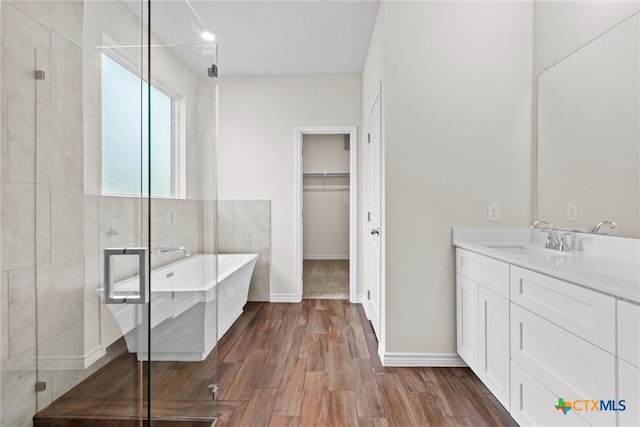 812 Waylon Cir, Killeen, TX 76542 - bathroom with vanity, a soaking tub, a shower stall, wood finished floors, and a spacious closet