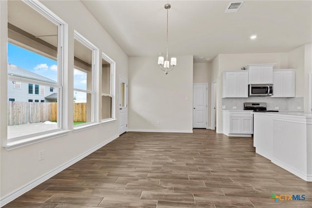 812 Waylon Cir, Killeen, TX 76542 - kitchen with appliances with stainless steel finishes, a chandelier, wood finished floors, white cabinets, and backsplash