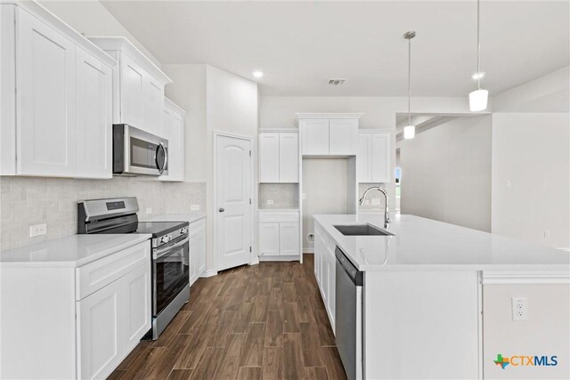 812 Waylon Cir, Killeen, TX 76542 - kitchen featuring appliances with stainless steel finishes, dark wood-type flooring, decorative backsplash, white cabinetry, and recessed lighting