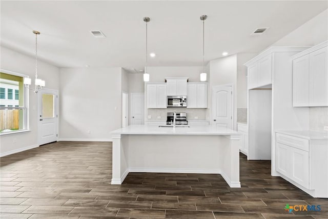 812 Waylon Cir, Killeen, TX 76542 - kitchen with appliances with stainless steel finishes, dark wood finished floors, tasteful backsplash, white cabinets, and light countertops