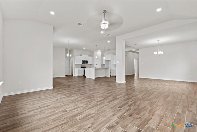 812 Waylon Cir, Killeen, TX 76542 - unfurnished living room featuring a chandelier, a ceiling fan, light wood-type flooring, and recessed lighting