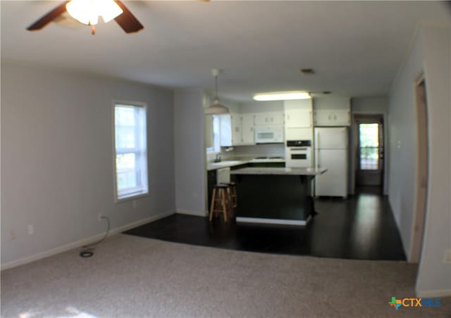 kitchen with ceiling fan, pendant lighting, white appliances, white cabinetry, and a kitchen breakfast bar