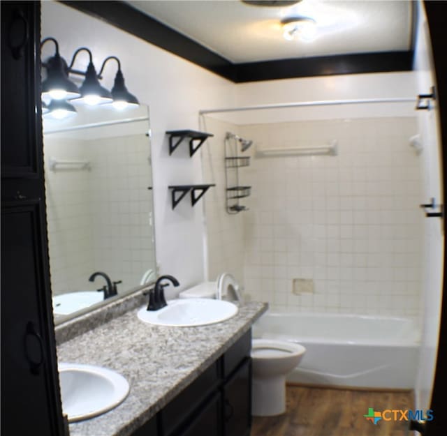 full bathroom with toilet, vanity, tiled shower / bath, and hardwood / wood-style floors