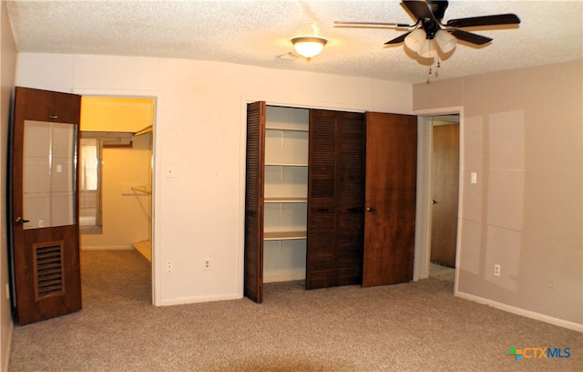 unfurnished bedroom with ceiling fan, light colored carpet, and a textured ceiling