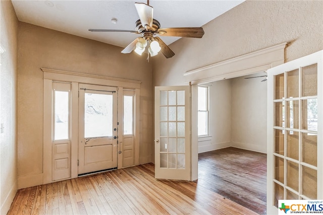 foyer entrance with ceiling fan, plenty of natural light, and light hardwood / wood-style flooring