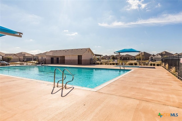 pool with a residential view, a patio, and fence