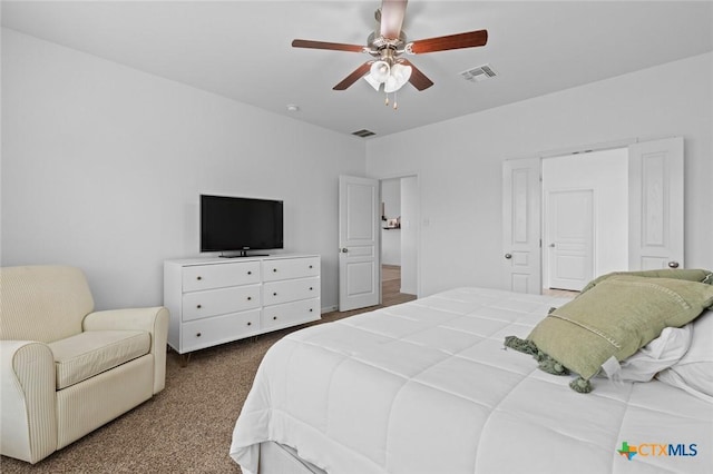 bedroom featuring visible vents, dark colored carpet, and ceiling fan