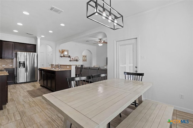 dining space featuring visible vents, a ceiling fan, recessed lighting, arched walkways, and crown molding