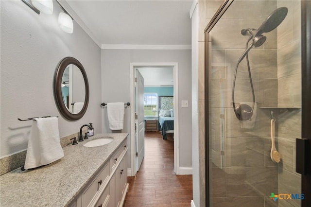 ensuite bathroom featuring vanity, wood finished floors, ensuite bathroom, ornamental molding, and a stall shower