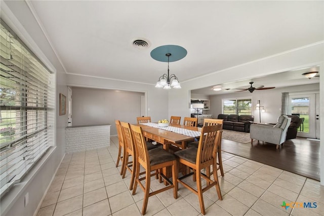 dining area with visible vents, light tile patterned floors, and ceiling fan with notable chandelier