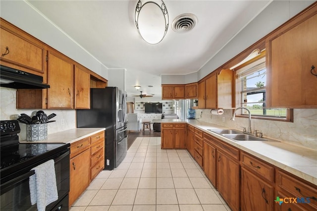 kitchen featuring brown cabinetry, a sink, black range with electric cooktop, and under cabinet range hood