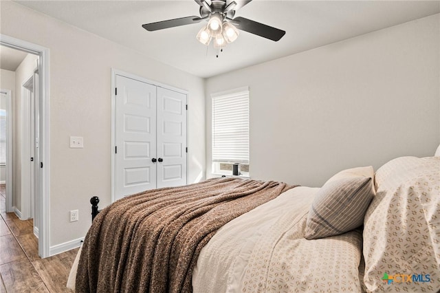 bedroom featuring ceiling fan, a closet, and light hardwood / wood-style flooring