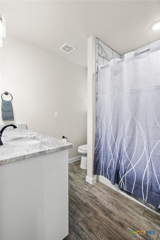 bathroom featuring vanity, hardwood / wood-style floors, and toilet