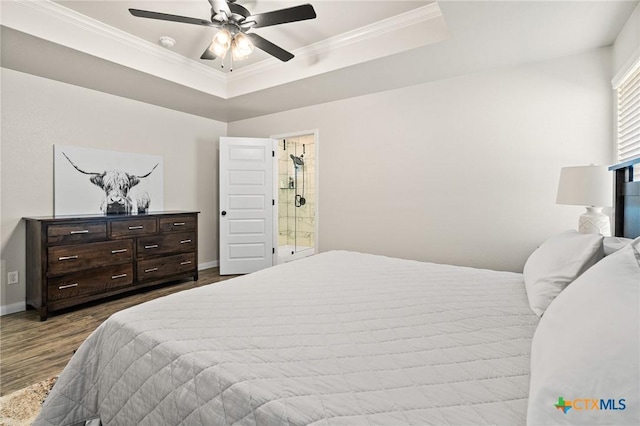 bedroom with ensuite bathroom, ornamental molding, a raised ceiling, hardwood / wood-style flooring, and ceiling fan